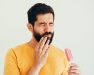 hombre con sensibilidad dental al comer un helado