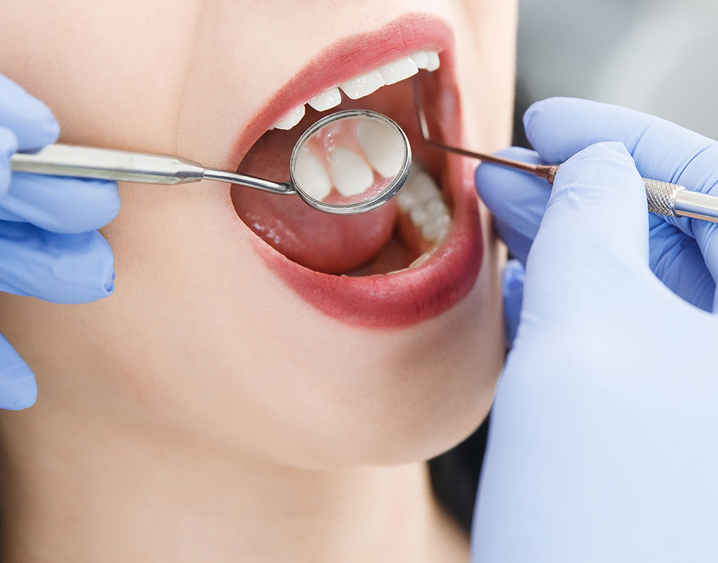 dentista inspecciona boca de mujer