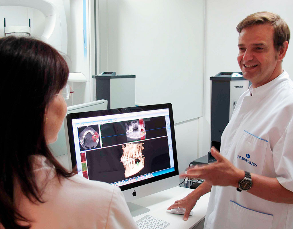 Doctor Fabregues explica un tratamiento dental por 3D a una paciente en su clínica de palma de mallorca