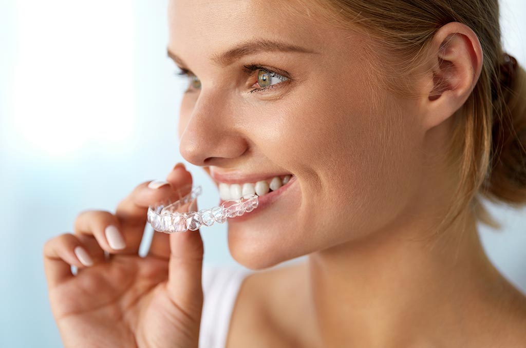 mujer sostiene férula invisalign