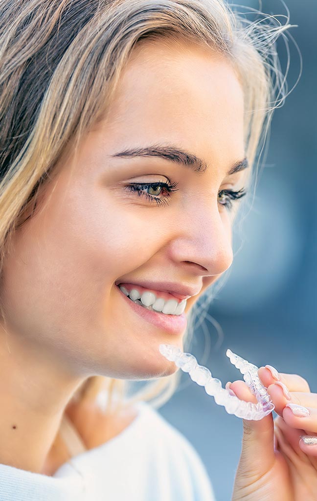 mujer sosteniendo funda de ortodoncia invisalign