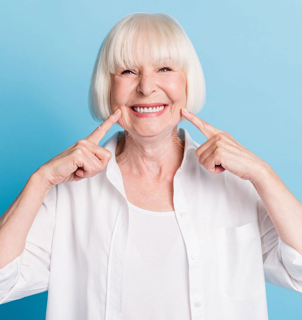 mujer mayor sonriendo tras un tratamiento de prótesis dental
